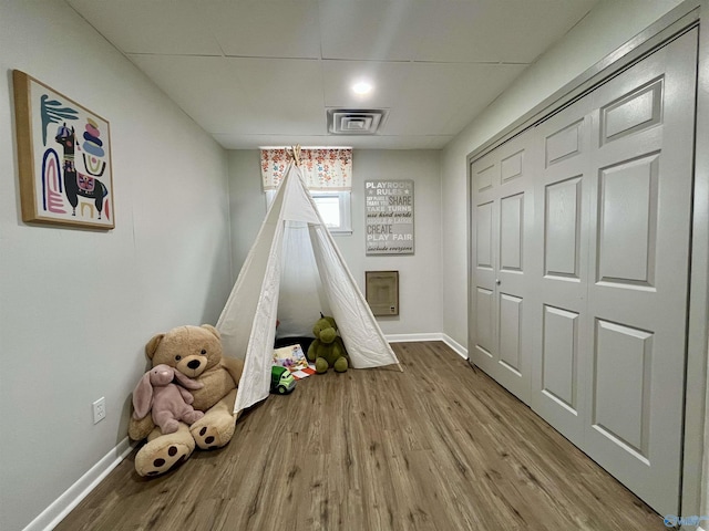 rec room with wood finished floors, baseboards, and visible vents