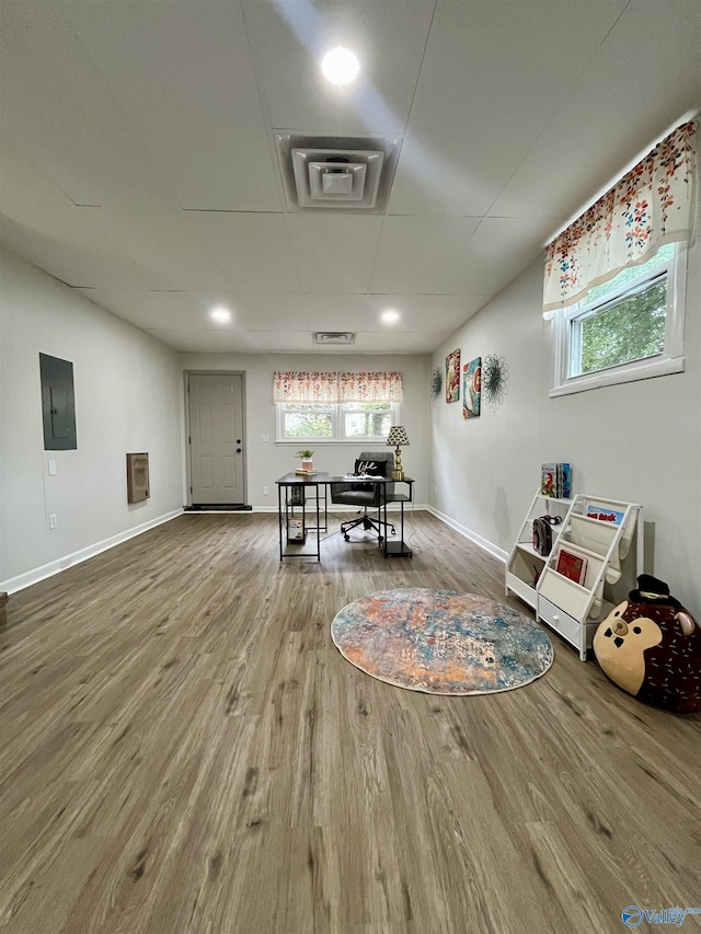 interior space with wood finished floors, baseboards, and electric panel
