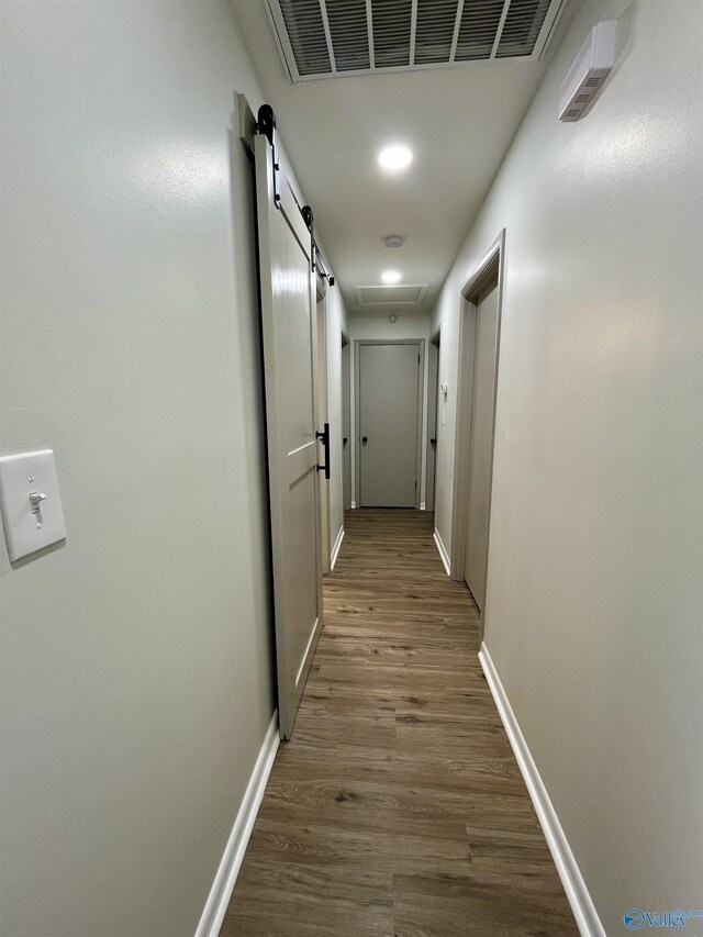corridor featuring wood finished floors, baseboards, visible vents, and recessed lighting