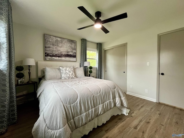 bedroom featuring wood finished floors, a closet, a ceiling fan, and baseboards