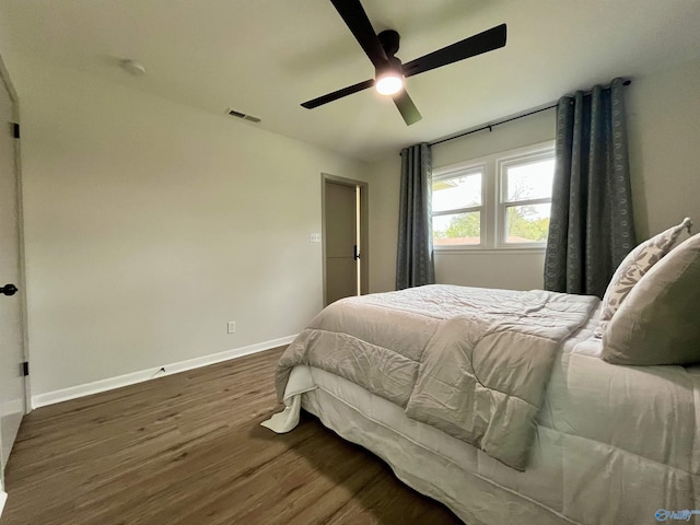 bedroom with visible vents, baseboards, ceiling fan, and wood finished floors