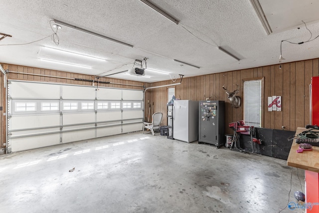 43 Terry Ln, Trinity, AL 35673 - garage featuring wood walls, a garage door opener, and freestanding refrigerator