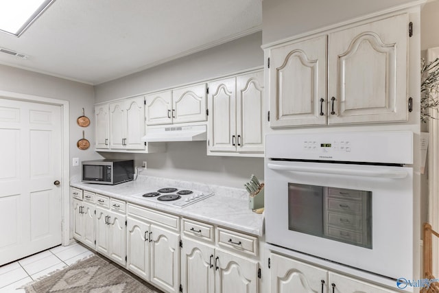 43 Terry Ln, Trinity, AL 35673 - kitchen featuring white appliances, under cabinet range hood, light countertops, light tile patterned flooring, and ornamental molding