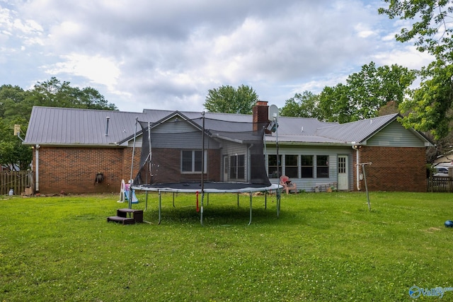 43 Terry Ln, Trinity, AL 35673 - rear view of property featuring a trampoline, a chimney, brick siding, and metal roof