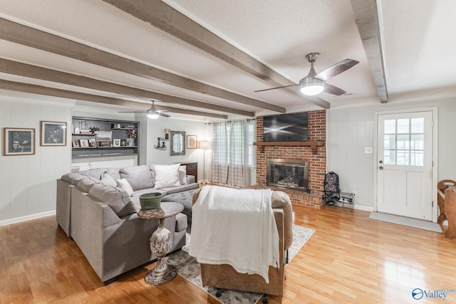 43 Terry Ln, Trinity, AL 35673 - living area featuring a ceiling fan, wood finished floors, beamed ceiling, a fireplace, and baseboards