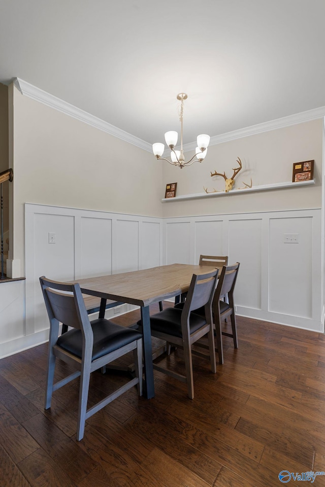 28622 Paseo Rd, Madison, AL 35756 - dining space featuring a decorative wall, crown molding, a chandelier, wainscoting, and dark wood-type flooring
