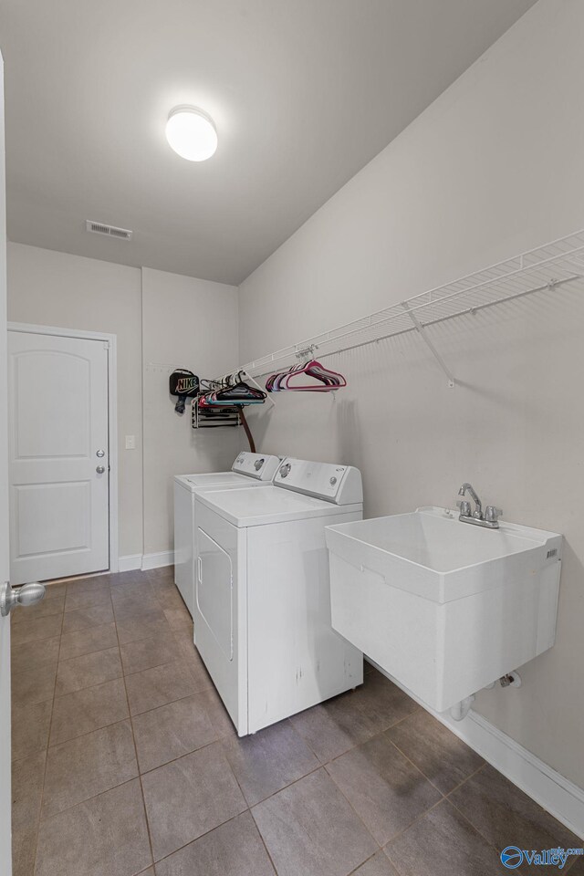 28622 Paseo Rd, Madison, AL 35756 - laundry area featuring washer and dryer, tile patterned flooring, and baseboards
