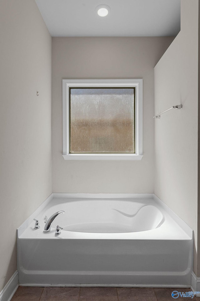 28622 Paseo Rd, Madison, AL 35756 - bathroom featuring healthy amount of natural light, a bath, tile patterned flooring, and baseboards