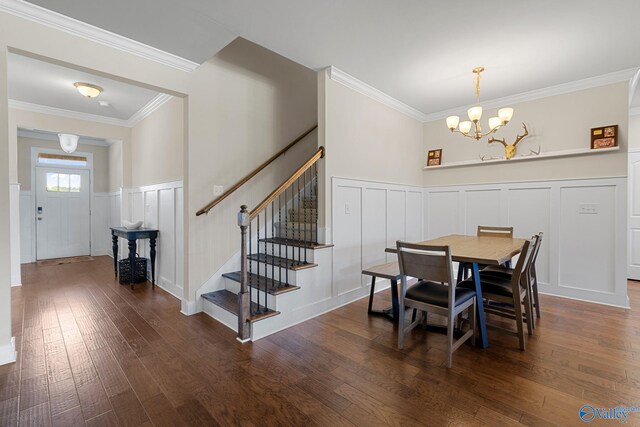 28622 Paseo Rd, Madison, AL 35756 - dining area with a decorative wall, a chandelier, stairs, dark wood finished floors, and ornamental molding