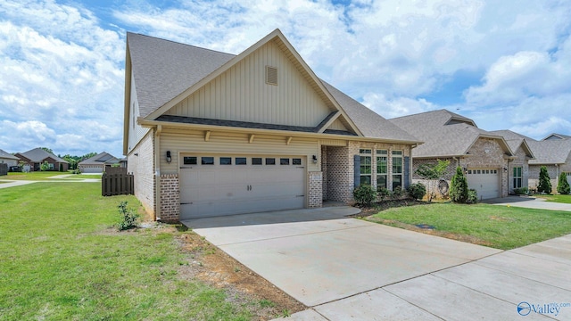 28622 Paseo Rd, Madison, AL 35756 - view of front of home with board and batten siding, brick siding, driveway, a front lawn, and a garage