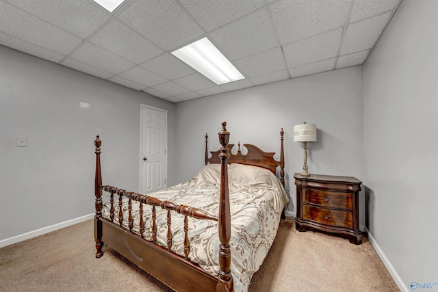 carpeted bedroom featuring a drop ceiling