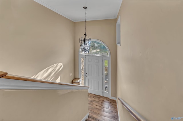 foyer entrance with a chandelier, hardwood / wood-style floors, and ornamental molding