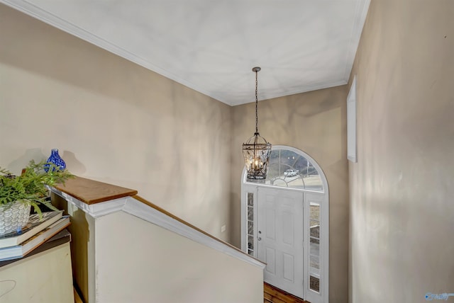 entrance foyer with hardwood / wood-style flooring, ornamental molding, and an inviting chandelier