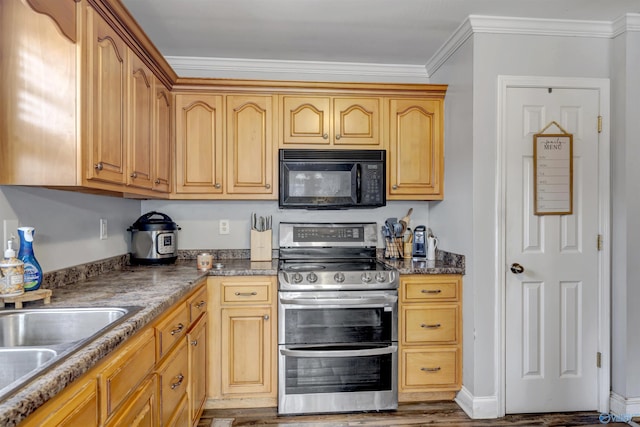 kitchen featuring dark stone countertops, stainless steel range, wood-type flooring, and ornamental molding