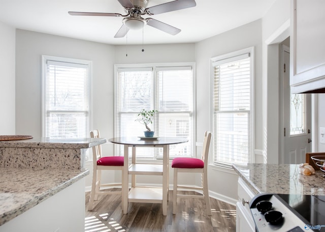 dining space with light wood-type flooring, baseboards, and a ceiling fan