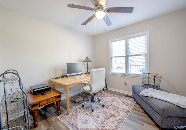 home office with a ceiling fan, baseboards, and wood finished floors