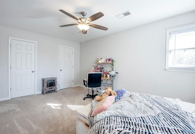 bedroom with carpet floors, heating unit, visible vents, and baseboards