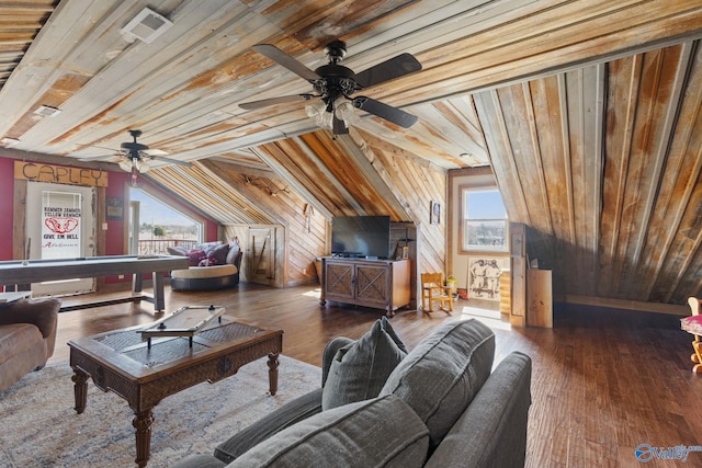 living room featuring wood walls, plenty of natural light, wood-type flooring, and a ceiling fan