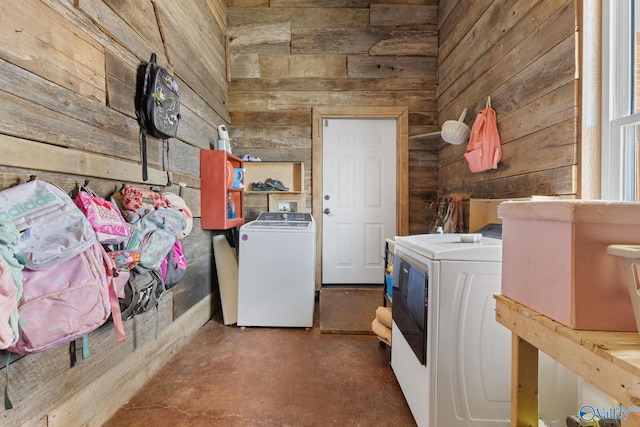 laundry room featuring wood walls, independent washer and dryer, and laundry area