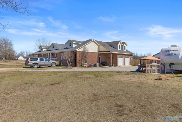 view of front of property with concrete driveway, an attached garage, a front yard, brick siding, and a playground