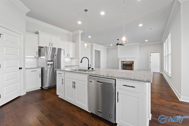 kitchen featuring sink, an island with sink, tasteful backsplash, white cabinetry, and stainless steel appliances