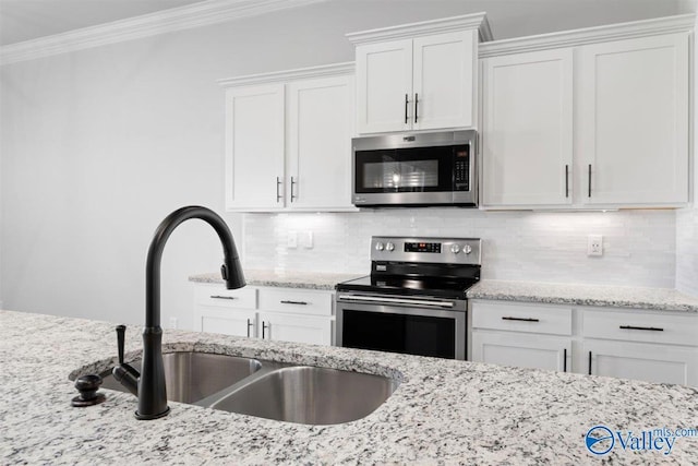 kitchen with crown molding, sink, tasteful backsplash, white cabinetry, and stainless steel appliances