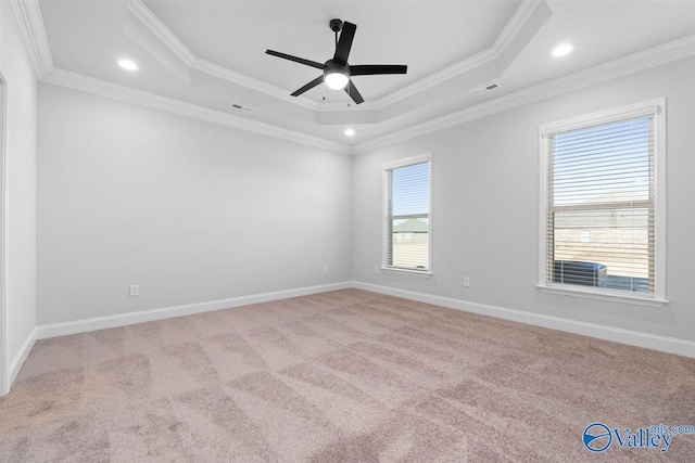 carpeted empty room featuring a tray ceiling, ceiling fan, and ornamental molding