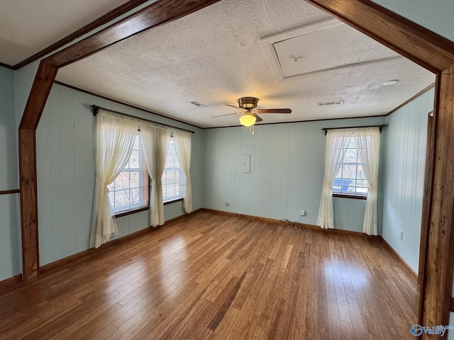 spare room featuring wood-type flooring, a textured ceiling, and a wealth of natural light