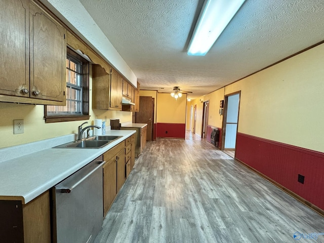 kitchen with sink, a textured ceiling, light hardwood / wood-style flooring, dishwasher, and ceiling fan