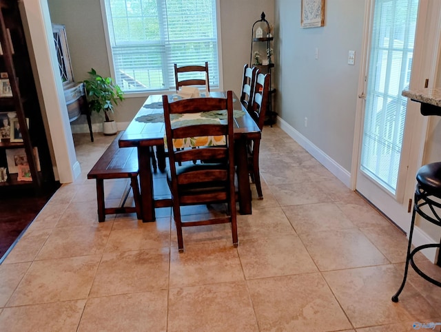 dining area featuring light tile patterned floors, baseboards, and a wealth of natural light