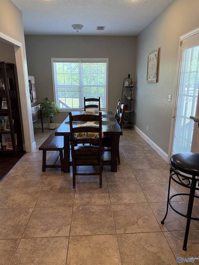 dining space with visible vents, baseboards, and tile patterned floors