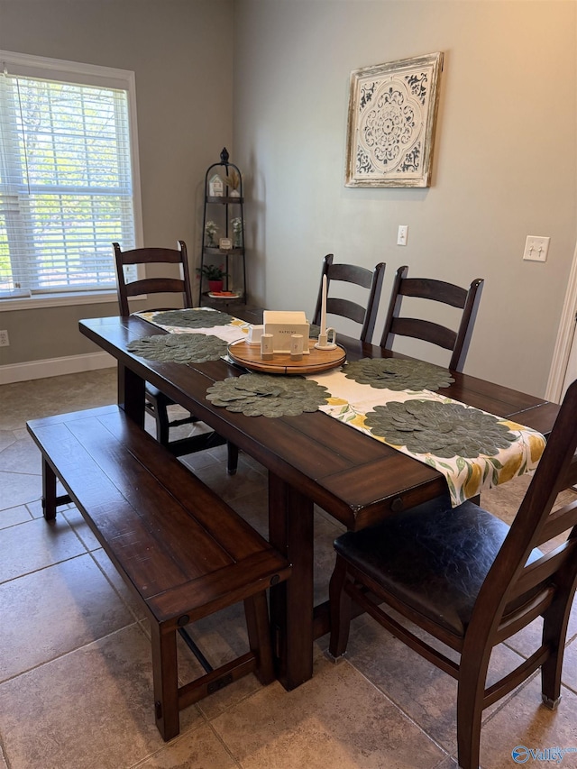 tiled dining room featuring baseboards