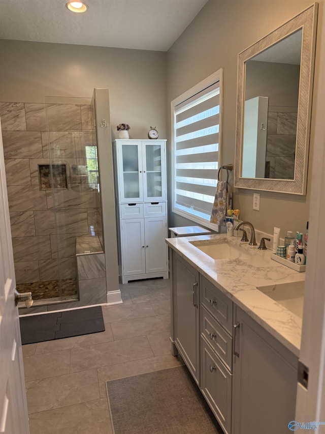 bathroom featuring a sink, double vanity, recessed lighting, tile patterned floors, and tiled shower
