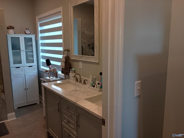 full bathroom featuring double vanity, a sink, and tile patterned flooring
