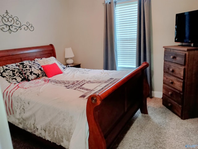 bedroom featuring baseboards and light carpet