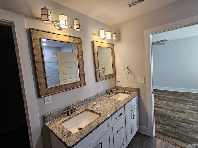 bathroom featuring visible vents, wood finished floors, baseboards, and a sink