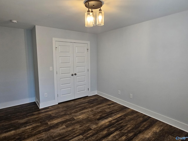 interior space featuring baseboards and dark wood finished floors