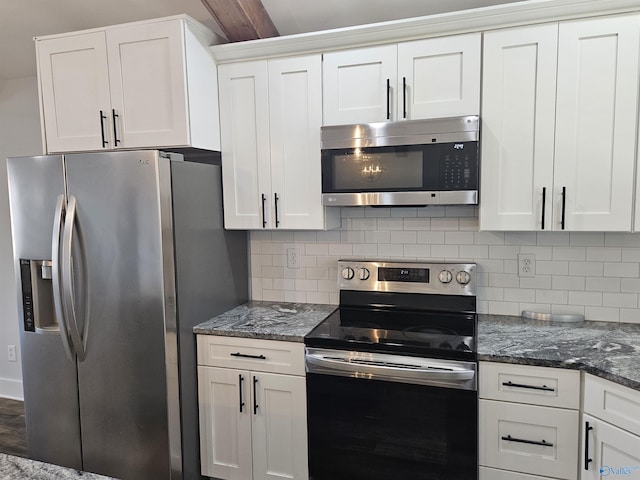 kitchen featuring decorative backsplash, dark stone counters, white cabinetry, and stainless steel appliances