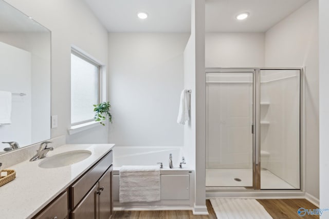 bathroom featuring vanity, wood-type flooring, and independent shower and bath