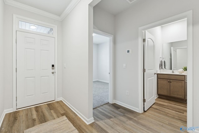 entryway featuring ornamental molding and light wood-type flooring