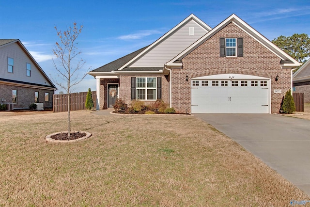 traditional-style house featuring a front yard, a garage, fence, concrete driveway, and brick siding