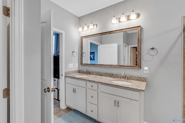 full bathroom with double vanity and a sink