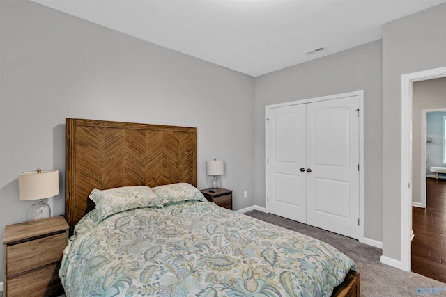 carpeted bedroom featuring a closet, visible vents, and baseboards