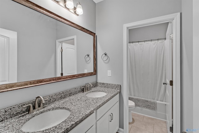 bathroom featuring tile patterned floors, double vanity, a sink, and toilet