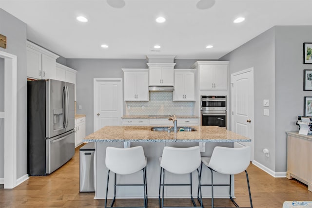 kitchen with a sink, appliances with stainless steel finishes, and white cabinetry