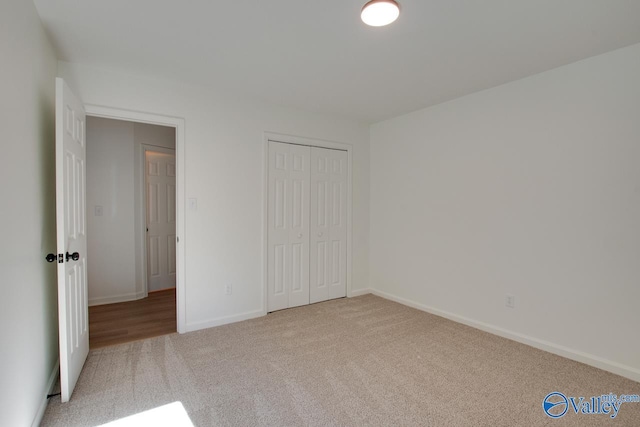 unfurnished bedroom featuring light carpet and a closet