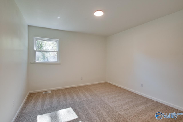 spare room featuring light colored carpet