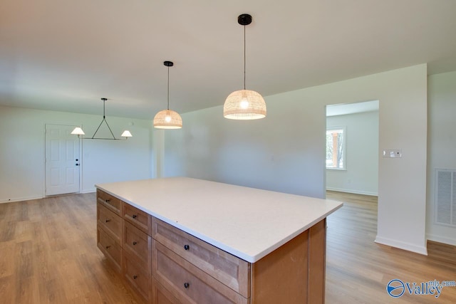 kitchen featuring pendant lighting, light hardwood / wood-style floors, and a kitchen island