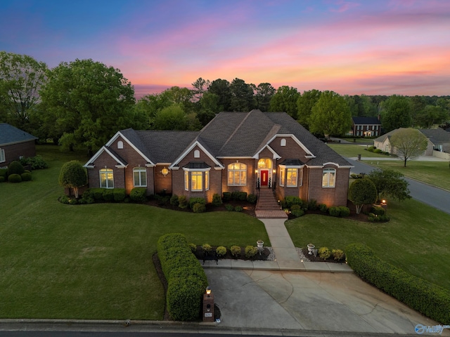 view of front of home featuring brick siding and a front lawn