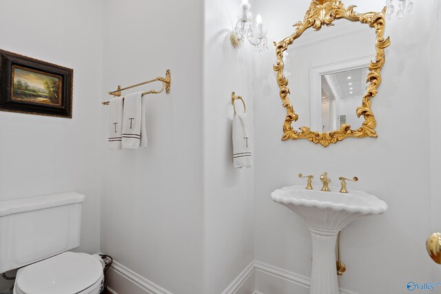 bathroom with toilet and baseboards